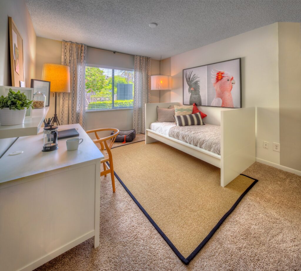 Bedroom with carpet, large window, and accent wall