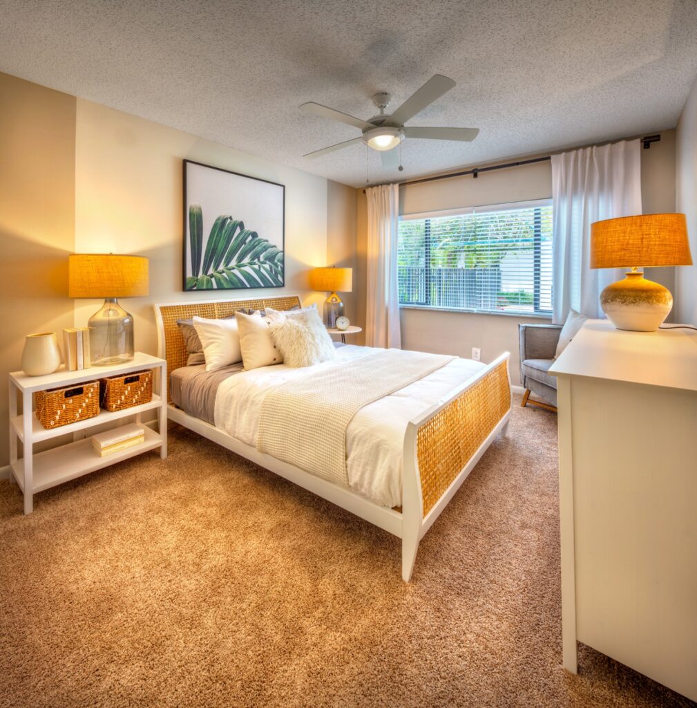 Bedroom with carpet, large window, ceiling fan, and accent wall