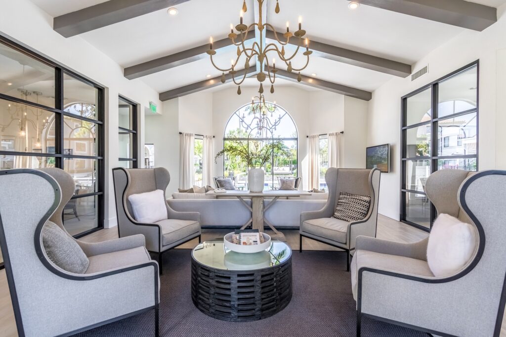 Leasing office waiting area with couch, table, and chairs with property employee offices to the left.