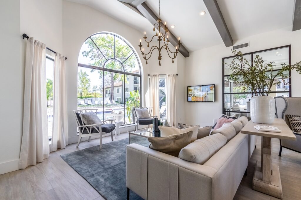 Leasing office waiting area with couch, table, and chairs with view of the pool in the back