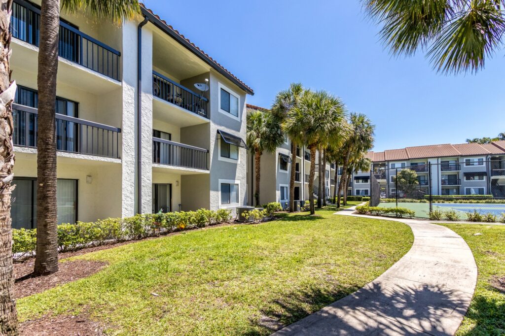 Outdoor walkway leading to tennis courts in courtyard of the property.