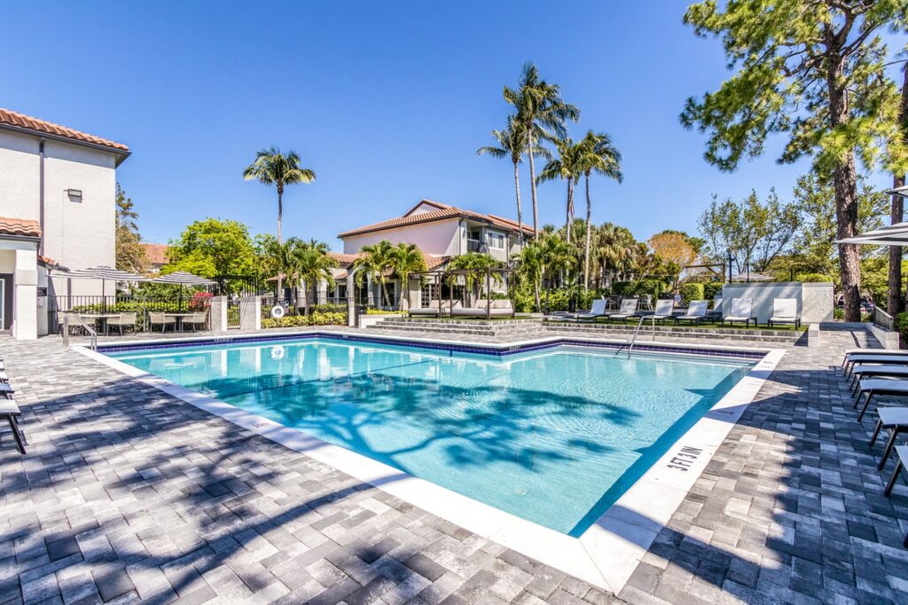 Pool with both shaded lounge chairs and unshaded. With cabanas and umbrella table and chairs.