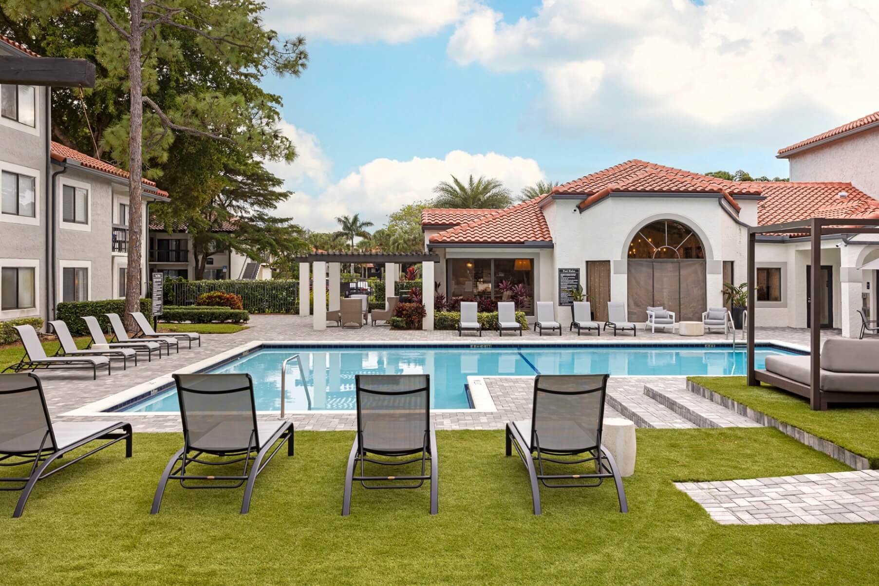 Pool area with chairs, lounge chairs, and cabana